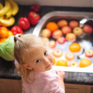 Child demonstarting washing fruit