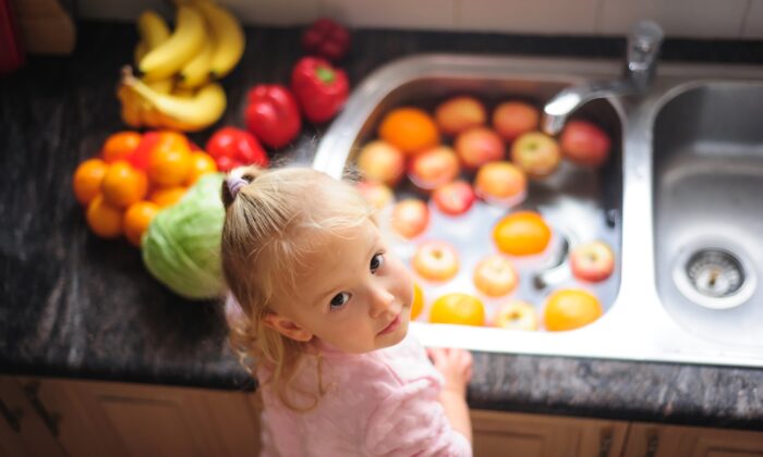 Child demonstarting washing fruit