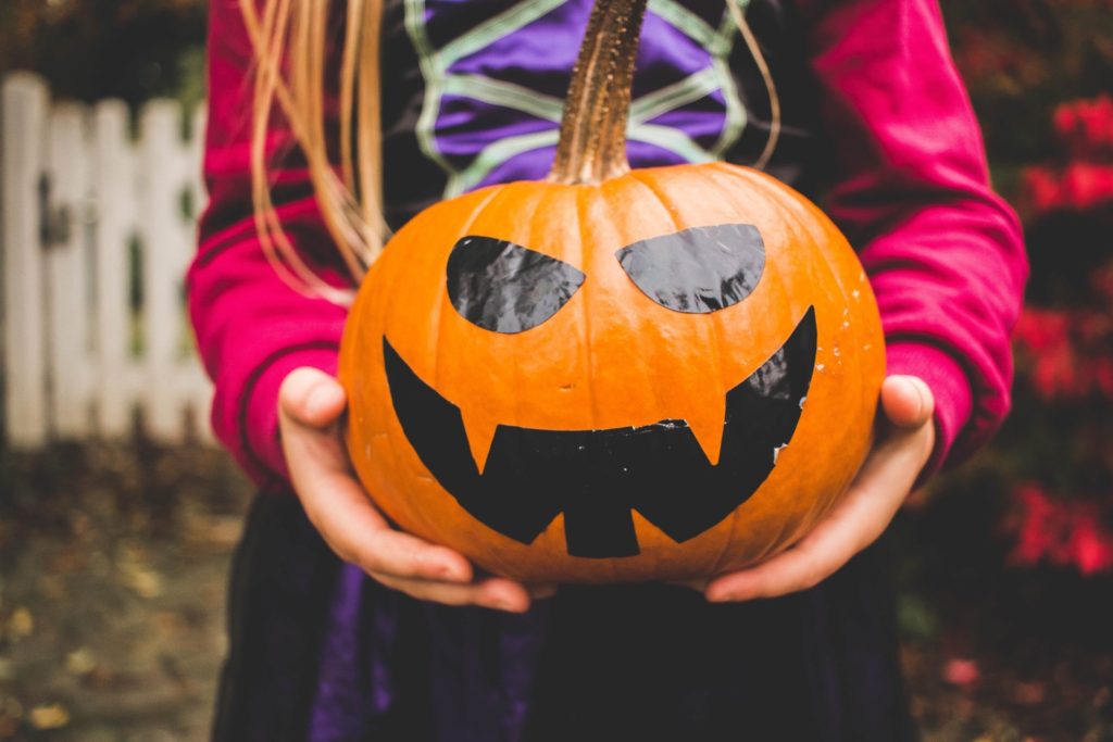 child holding pumpkin for halloween