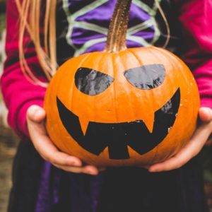 child holding pumpkin for halloween