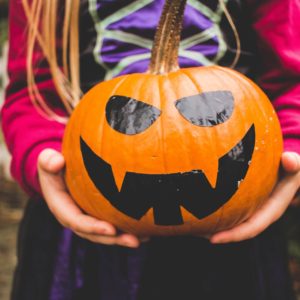 child holding pumpkin for halloween